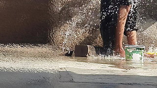 Indian sister-in-law is bathing in the open courtyard of the house, putting a finger in her burrow and rubbing the body, sister-in-law is washing the bathroom.