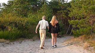 An old guy and a young girl are having sex in nature
