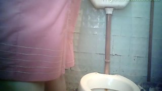 Pale skin brunette lady filmed from front side in the toilet