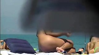 Nudist beach voyeur spies on a slender teen with perky boobs
