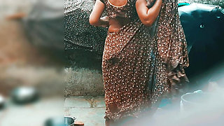 The desi sister-in-law of the village opened the drenched saree and took a bath in the open bathroom.