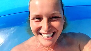 Milf seductress fingering her shaved pussy in the pool