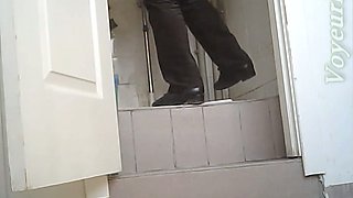 White chick in ugly baggy black pants pissing in the toilet