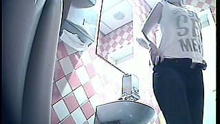 Brunette young cutie in black pants shows her ass and pisses in the toilet