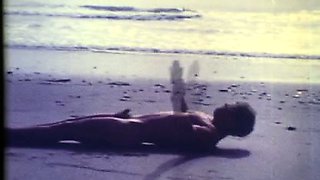 Beautiful vintage boy wanders the beach in the nude