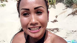 Thai beauty alone at the beach, pleasures herself with long locks flowing and exotic toys